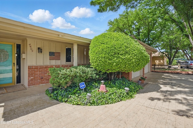 4405 56th St, Lubbock, TX 79414 - view of front of house featuring brick siding, a garage, board and batten siding, and a porch