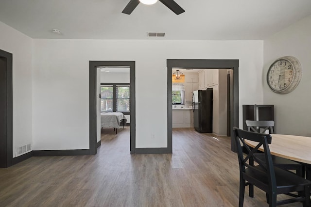 dining space with ceiling fan and wood-type flooring