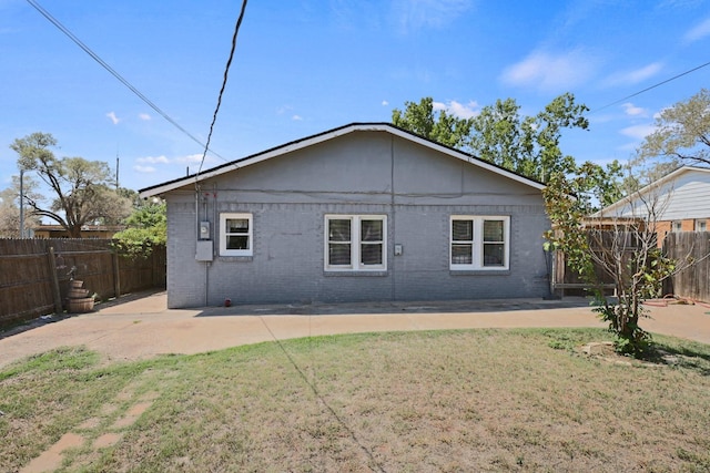 view of side of property with a patio and a lawn