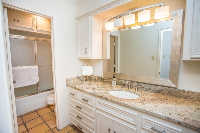 full bathroom with vanity, tile patterned floors, toilet, and combined bath / shower with glass door