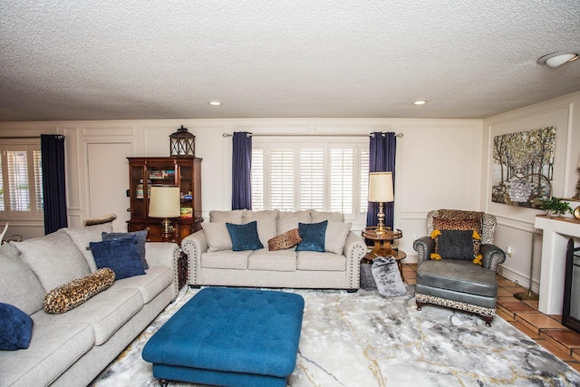 living room with tile patterned flooring, a wealth of natural light, and a textured ceiling