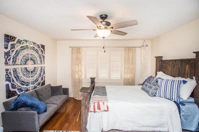 bedroom with ceiling fan, dark hardwood / wood-style flooring, and a textured ceiling