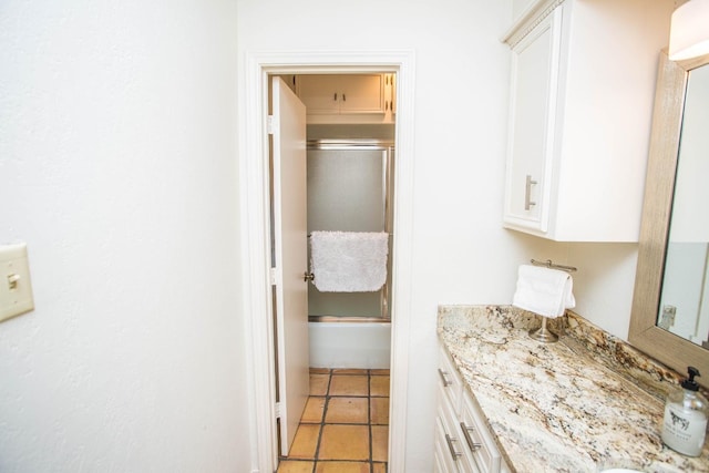 bathroom with tile patterned floors, vanity, and combined bath / shower with glass door