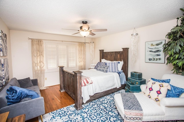 bedroom featuring hardwood / wood-style flooring, ceiling fan, and a textured ceiling