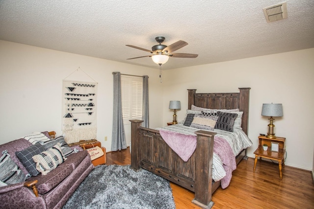 bedroom with ceiling fan, light hardwood / wood-style flooring, and a textured ceiling