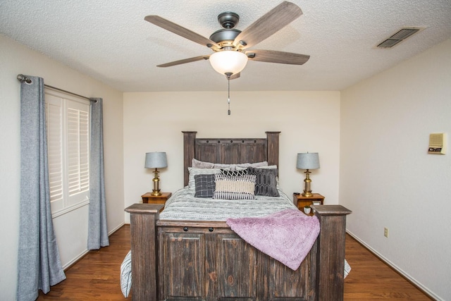 bedroom featuring ceiling fan, dark hardwood / wood-style floors, and a textured ceiling