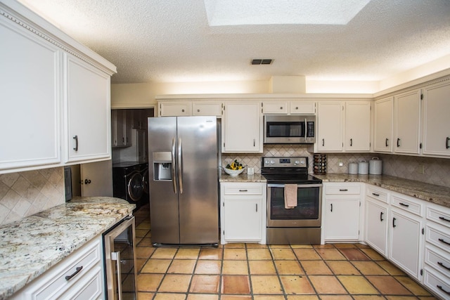 kitchen with white cabinetry, appliances with stainless steel finishes, beverage cooler, and decorative backsplash