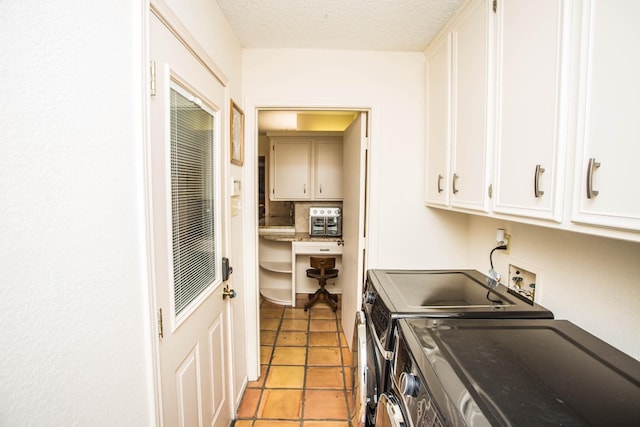 laundry room featuring cabinets, light tile patterned floors, washer and dryer, and a textured ceiling