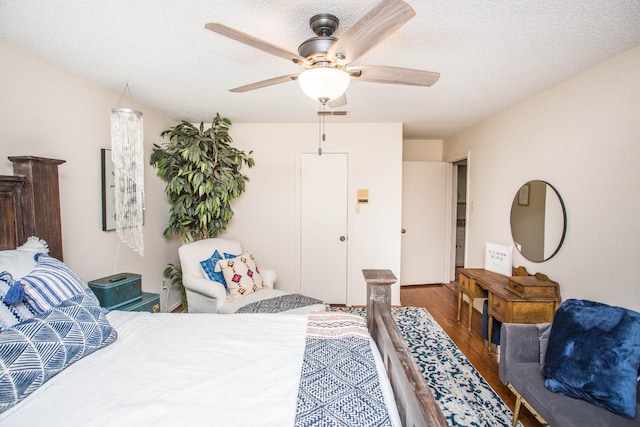 bedroom featuring ceiling fan, dark wood-type flooring, and a textured ceiling