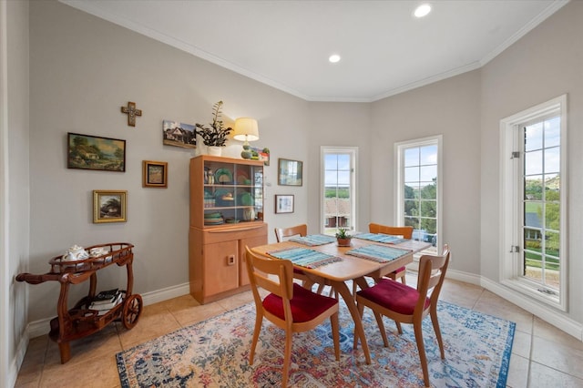 dining space with baseboards, crown molding, and light tile patterned floors