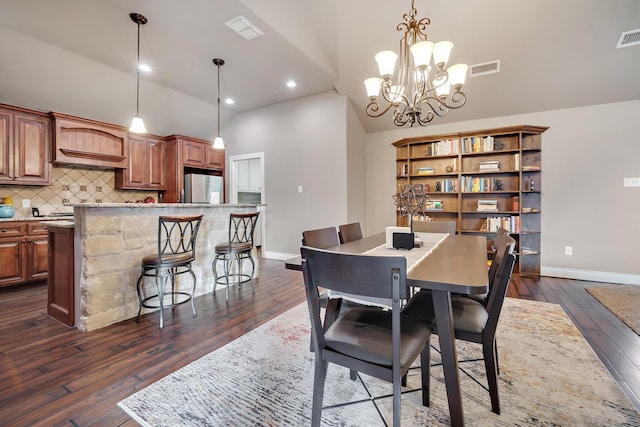 dining space with dark hardwood / wood-style floors, a chandelier, and high vaulted ceiling