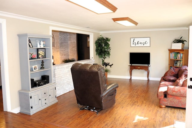 living area with ornamental molding, wood finished floors, and baseboards