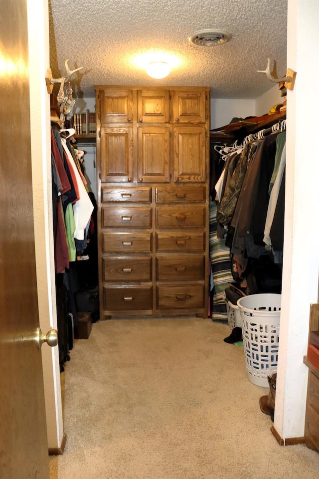 walk in closet with light colored carpet and visible vents