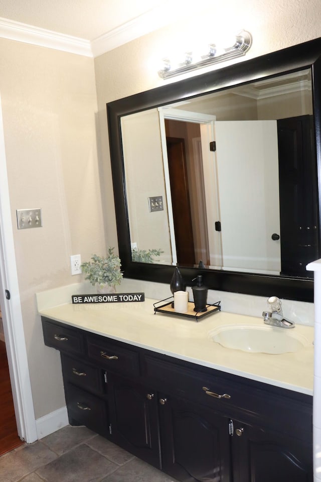 bathroom featuring tile patterned floors, baseboards, crown molding, and vanity