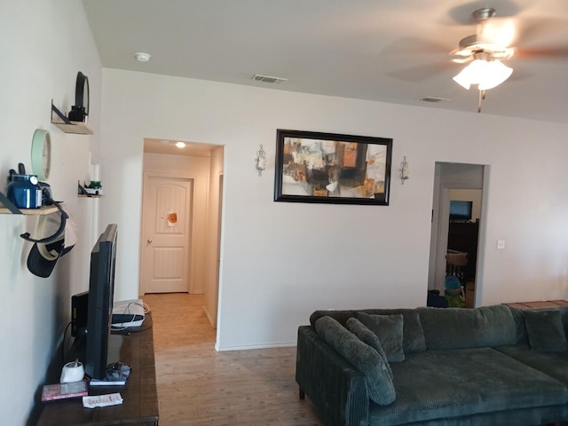 living room with light hardwood / wood-style flooring and ceiling fan