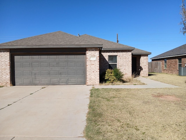 view of front of house featuring a garage, central AC, and a front yard