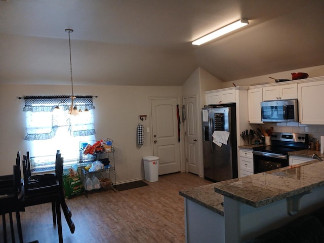 kitchen with white cabinetry, stainless steel appliances, decorative light fixtures, vaulted ceiling, and kitchen peninsula