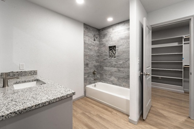 bathroom featuring vanity, hardwood / wood-style floors, and tiled shower / bath