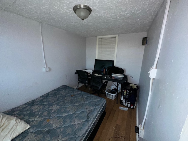 bedroom featuring hardwood / wood-style floors and a textured ceiling