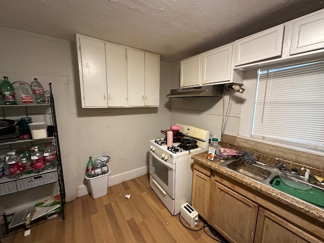 kitchen featuring sink, white cabinets, light wood-type flooring, and white gas range oven