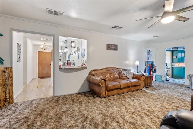 living room with crown molding, ceiling fan with notable chandelier, and light colored carpet