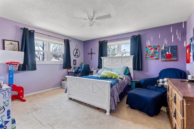 bedroom with ceiling fan, carpet flooring, and a textured ceiling