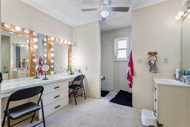 bathroom with ceiling fan, vanity, and a textured ceiling