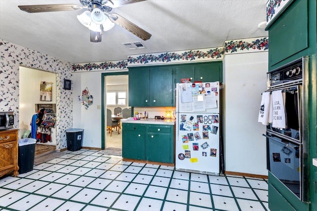 kitchen with double oven, ceiling fan, a textured ceiling, and white fridge