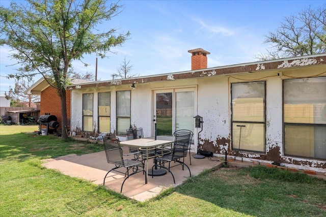 rear view of property with a patio area and a lawn