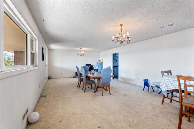 carpeted dining room featuring a textured ceiling and a notable chandelier