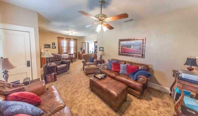 carpeted living room featuring ceiling fan and a textured ceiling