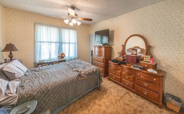 carpeted bedroom featuring ceiling fan and a textured ceiling