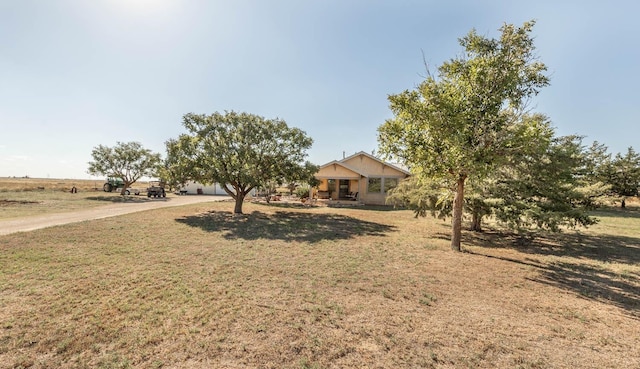 view of front of property with a rural view, covered porch, and a front lawn