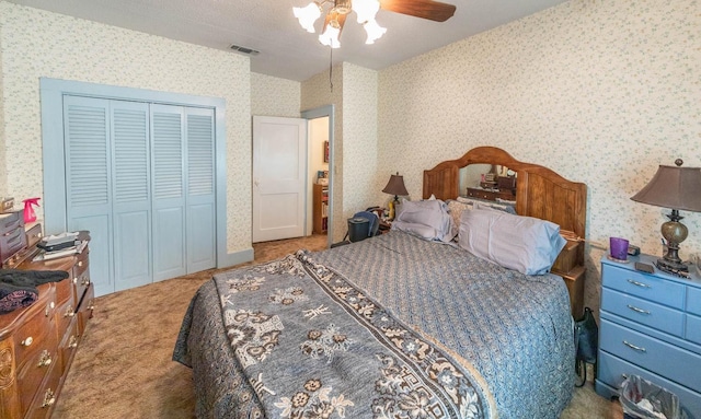 carpeted bedroom with ceiling fan and a closet