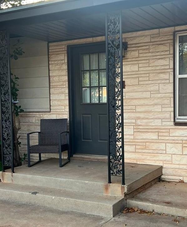 view of exterior entry with a porch