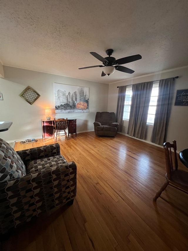 living room with hardwood / wood-style flooring, ceiling fan, and a textured ceiling