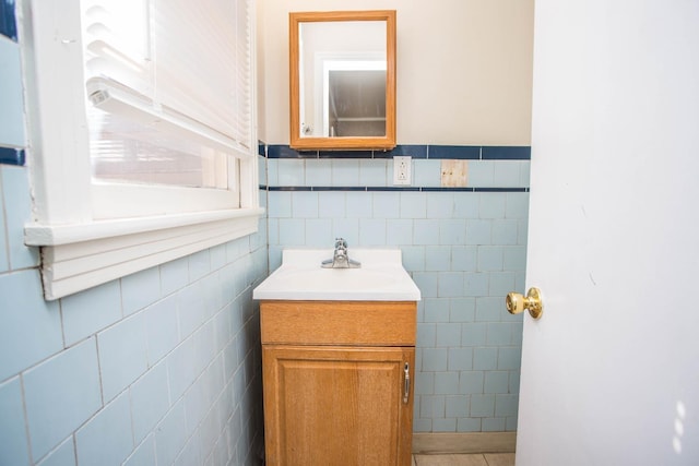 bathroom featuring vanity and tile walls