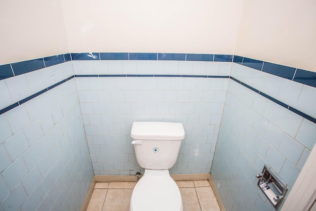 bathroom with tile patterned flooring, tile walls, and toilet