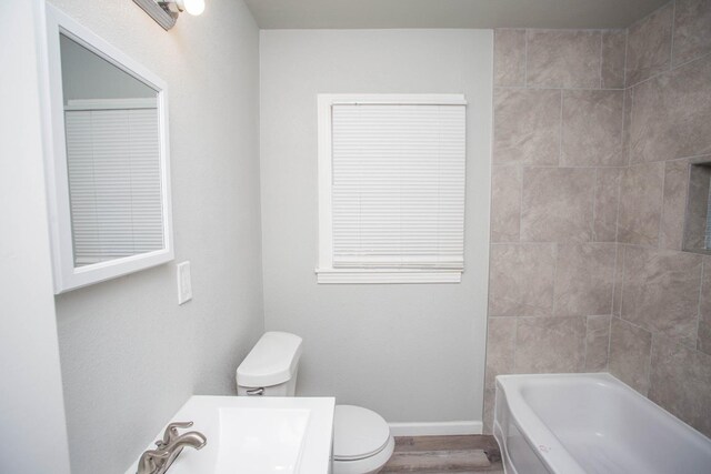 bathroom featuring toilet and tiled shower / bath combo