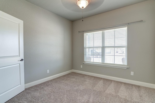 carpeted spare room featuring ceiling fan