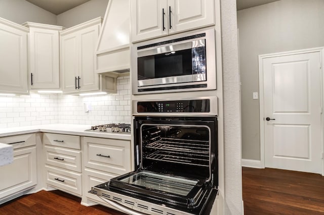 kitchen featuring premium range hood, white cabinetry, stainless steel appliances, and dark hardwood / wood-style floors