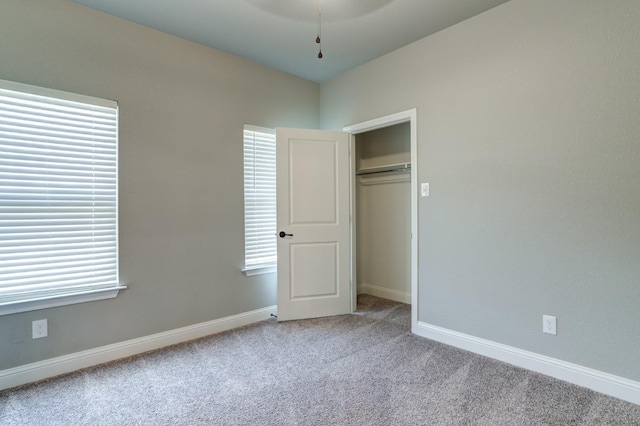 unfurnished bedroom featuring light colored carpet and a closet