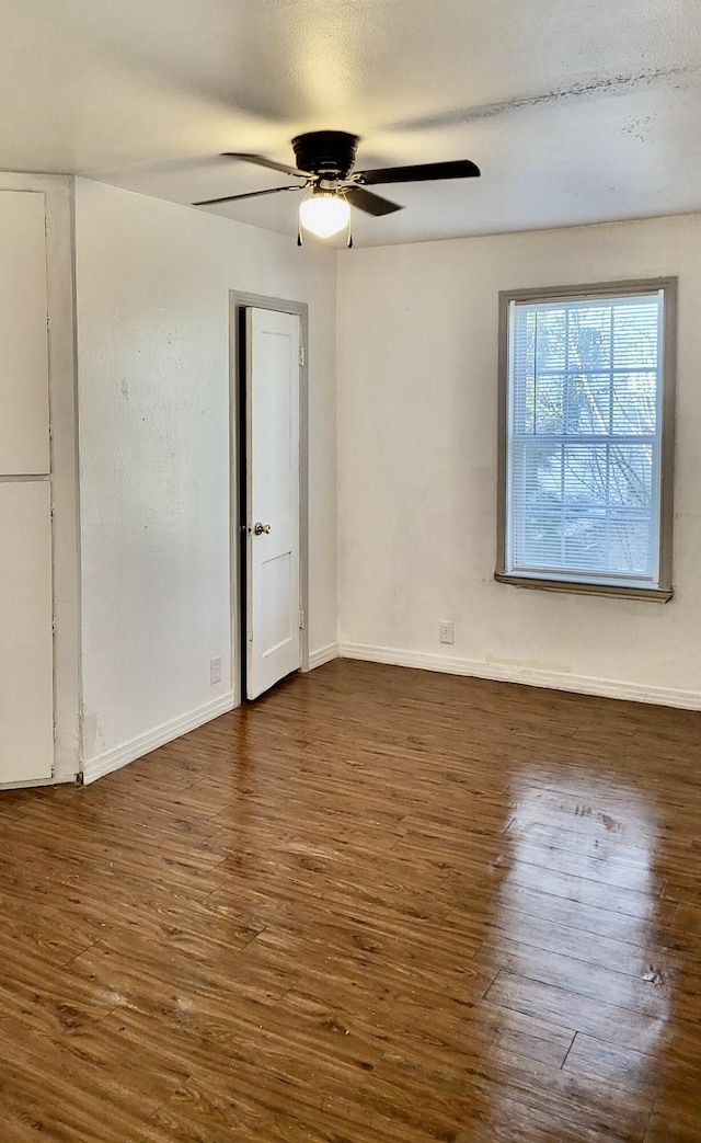 unfurnished room with ceiling fan and dark hardwood / wood-style flooring