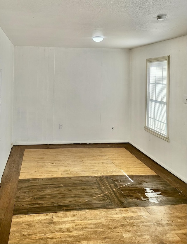 spare room with hardwood / wood-style flooring and a textured ceiling