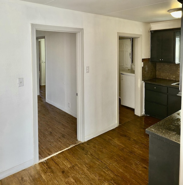 kitchen with tasteful backsplash, washer / dryer, and dark wood-type flooring