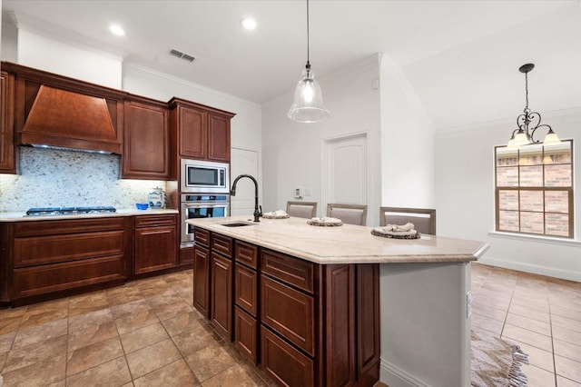 kitchen featuring sink, a kitchen island with sink, stainless steel appliances, tasteful backsplash, and custom exhaust hood