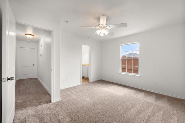 unfurnished bedroom with light carpet, ceiling fan, and ensuite bathroom