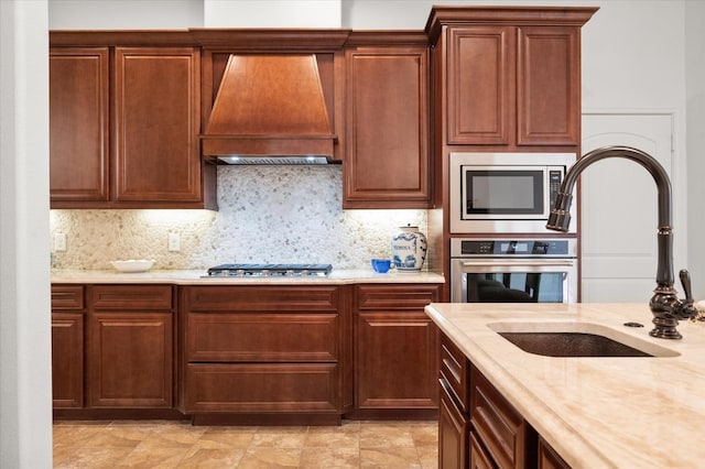 kitchen with custom exhaust hood, tasteful backsplash, sink, and stainless steel appliances