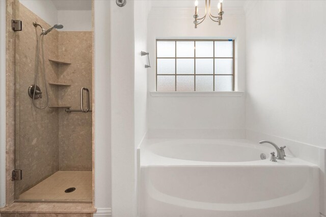 bathroom with an inviting chandelier, crown molding, and separate shower and tub