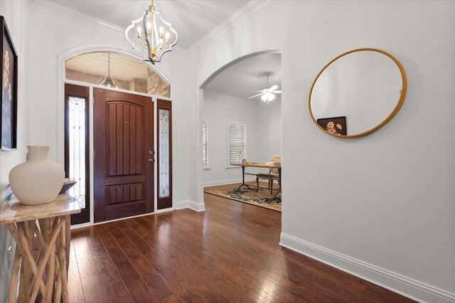 foyer featuring crown molding, dark wood-type flooring, and ceiling fan with notable chandelier